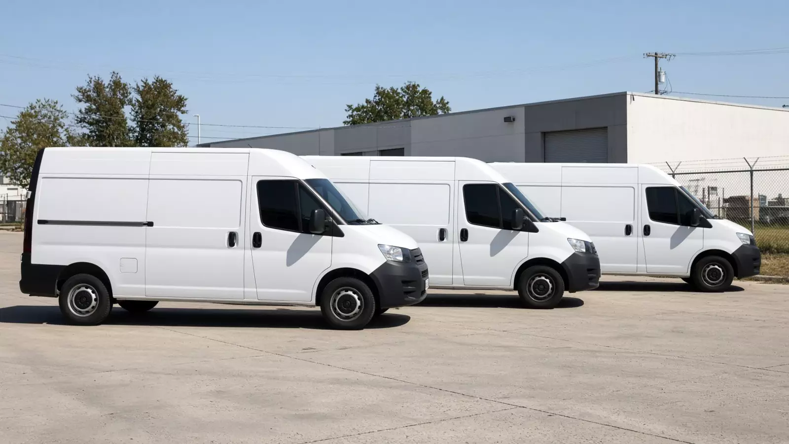 Three white delivery vans with dark window tint